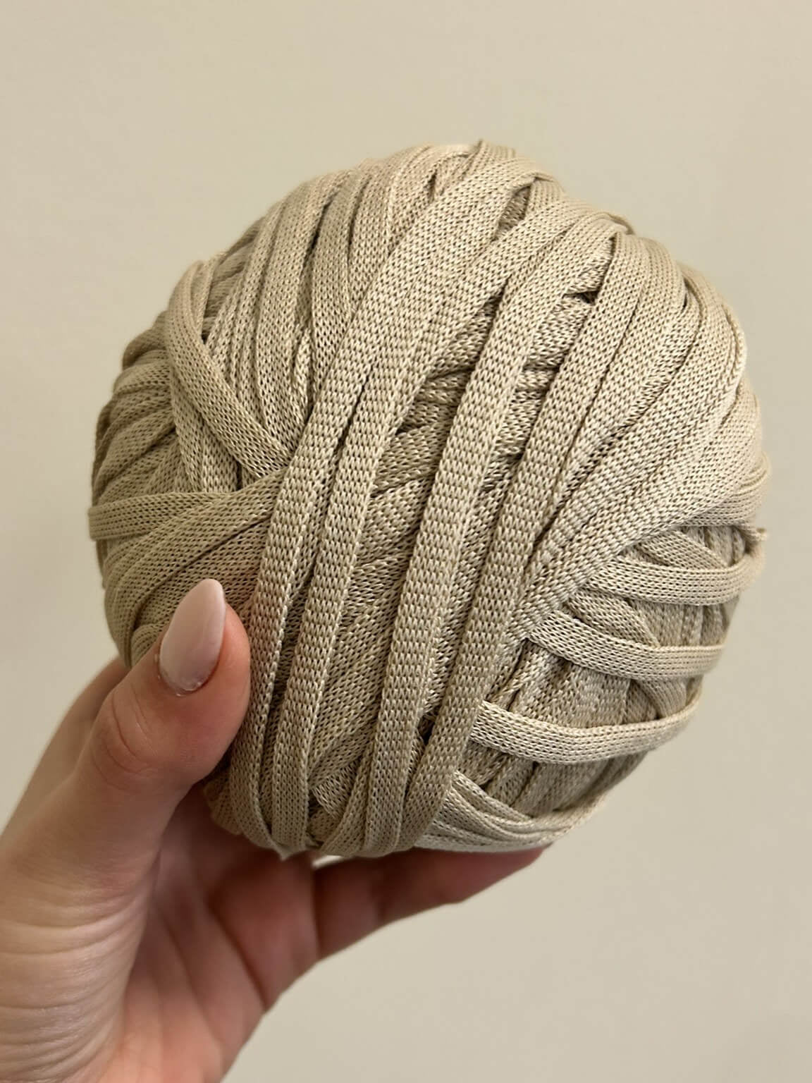 Fettuccia beige chiaro a forma di tubolare per realizzare borse all'uncinetto