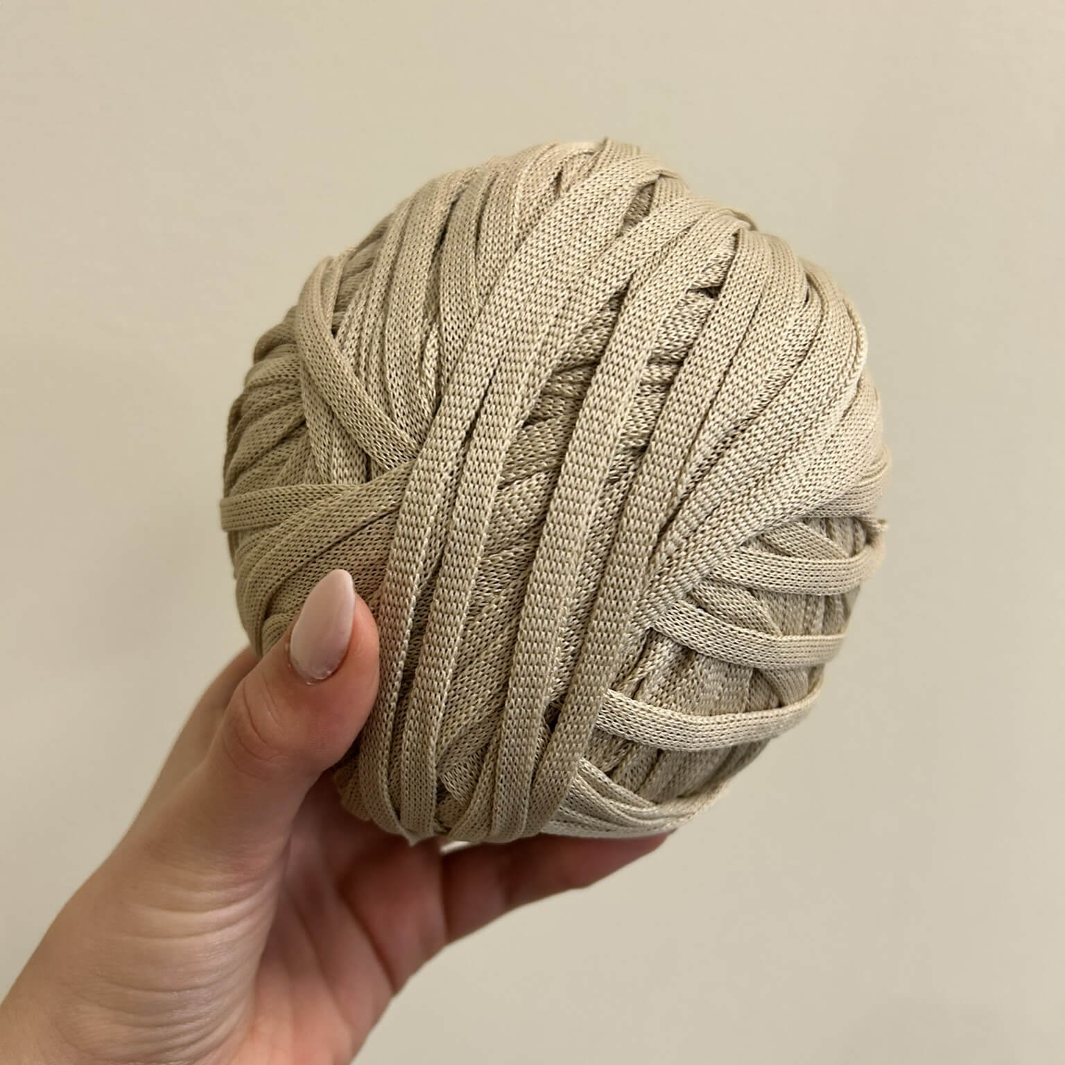 Fettuccia beige chiaro a forma di tubolare per realizzare borse all'uncinetto