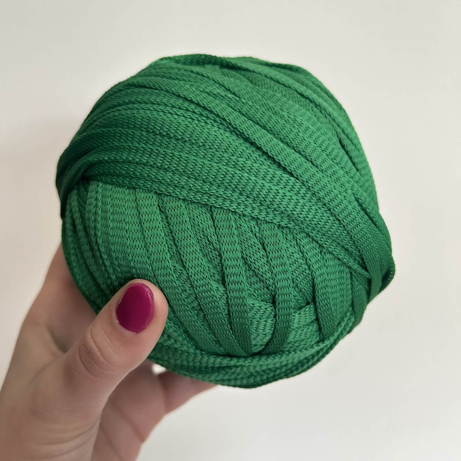 Fettuccia verde a forma di tubolare per realizzare borse all'uncinetto
