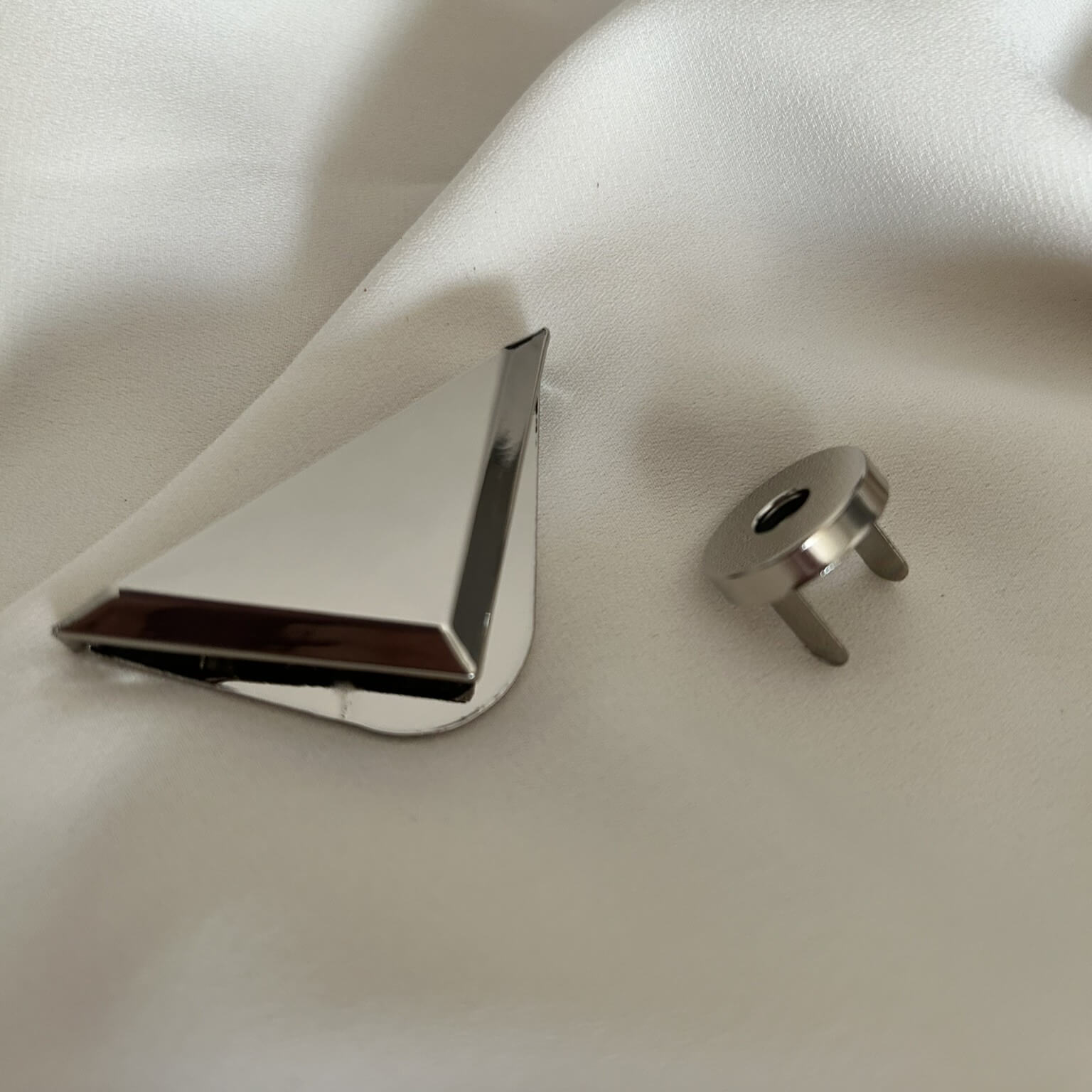 Chiusura a cartella a forma di triangolo rovesciato dal colore oro e argento